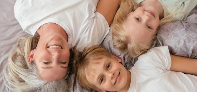 grandmother with grandchildren laying on bed