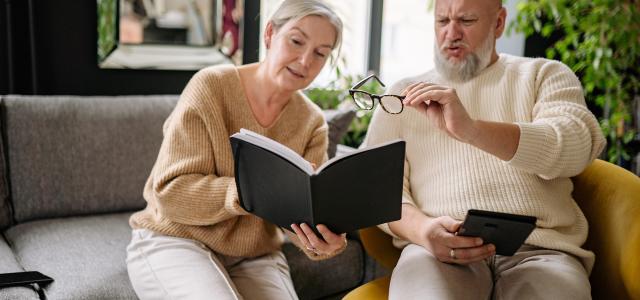 couple looking at books together on sofa